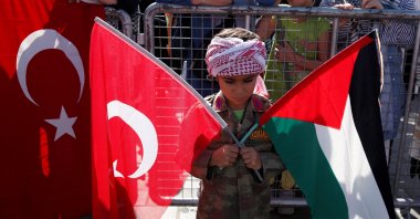 A boy holds Turkish and Palestinian flags during a protest to express support for Palestinians in Gaza, Istanbul, Türkiye, Oct. 6, 2024. (Reuters Photo)