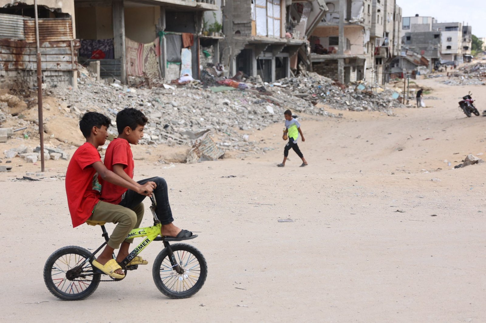 Children ride a bicycle across a war-devastated street in Gaza City, Palestine, Oct. 2, 2024. (AFP Photo)