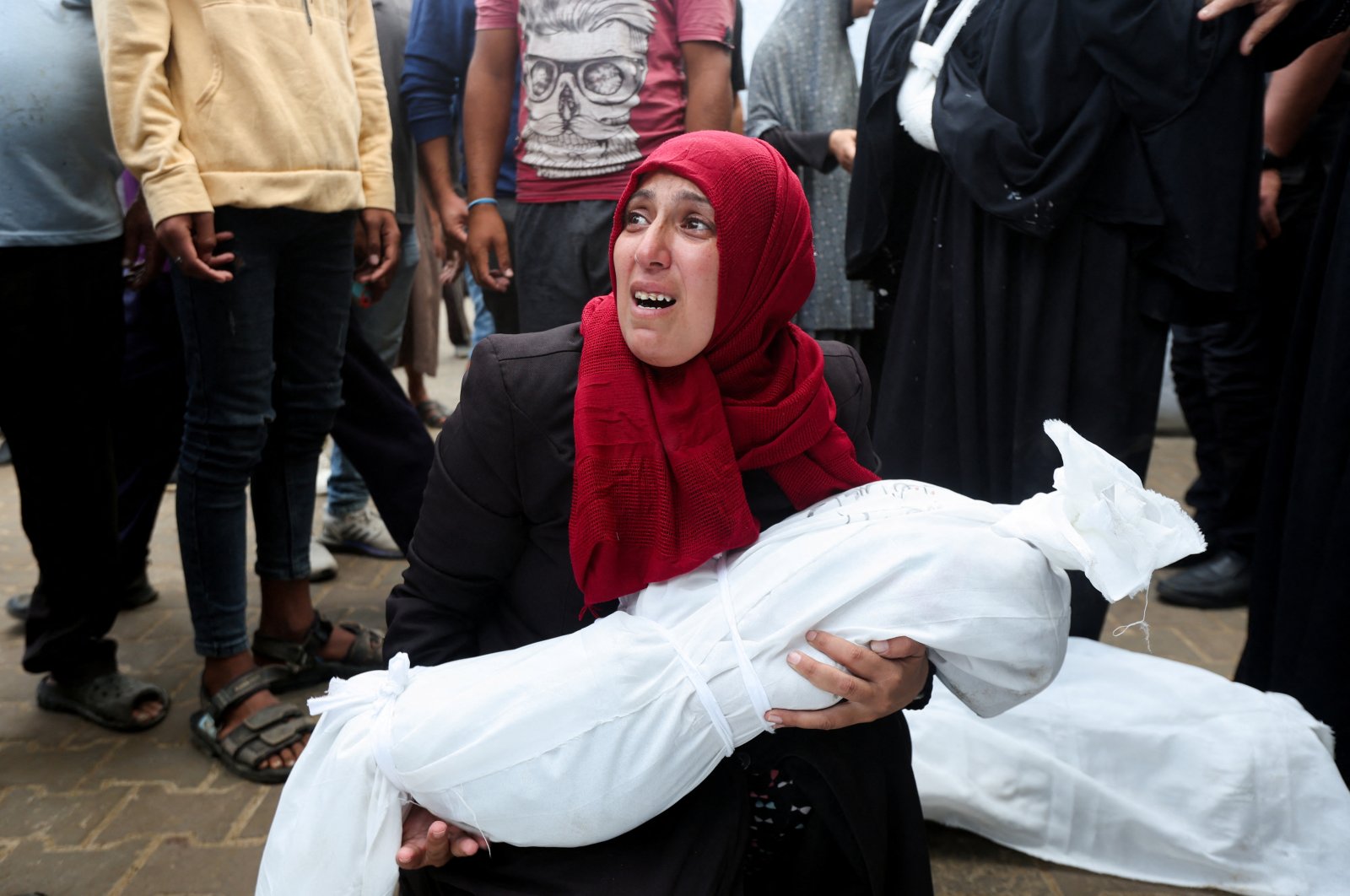 A Palestinian woman holds the body of a child who was killed by Israeli strikes at Al-Aqsa Martyrs Hospital, Deir Al-Balah, central Gaza Strip, Palestine, Oct. 8, 2024. (Reuters Photo)