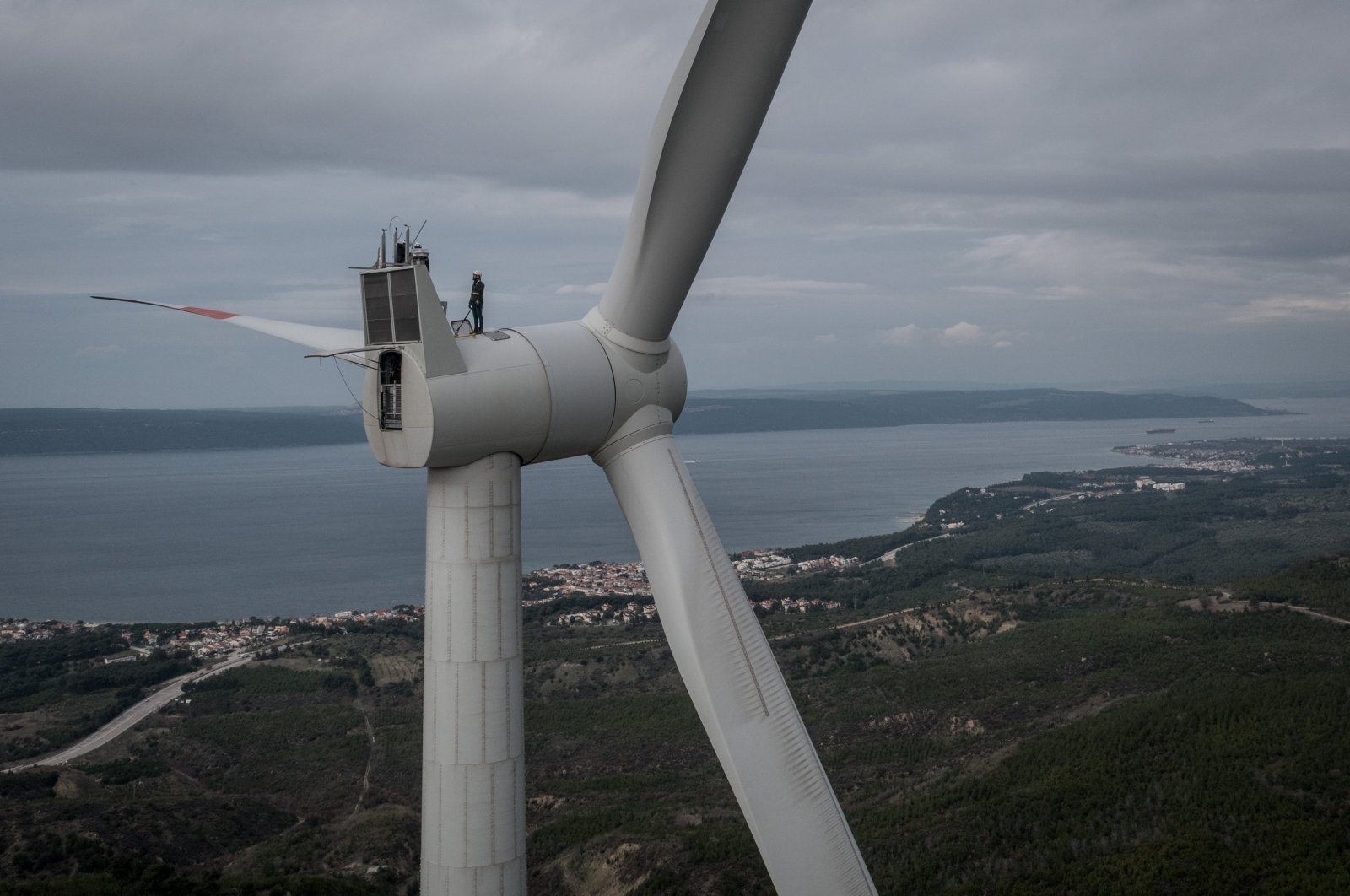 Employees from Akfen Renewable Energy Group’s, Çanakkale Wind Power Plant, do a routine maintenance check of equipment on the top of a wind turbine in Canakkale, Türkiye, Dec. 17, 2021. (Getty Images Photo)