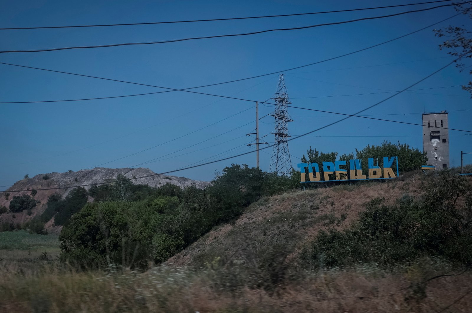 A view shows a damaged sign that reads &quot;Toretsk,&quot; panted in the colors of the Ukrainian flag, in the town of Toretsk, Ukraine, July 3, 2024. (Reuters Photo)