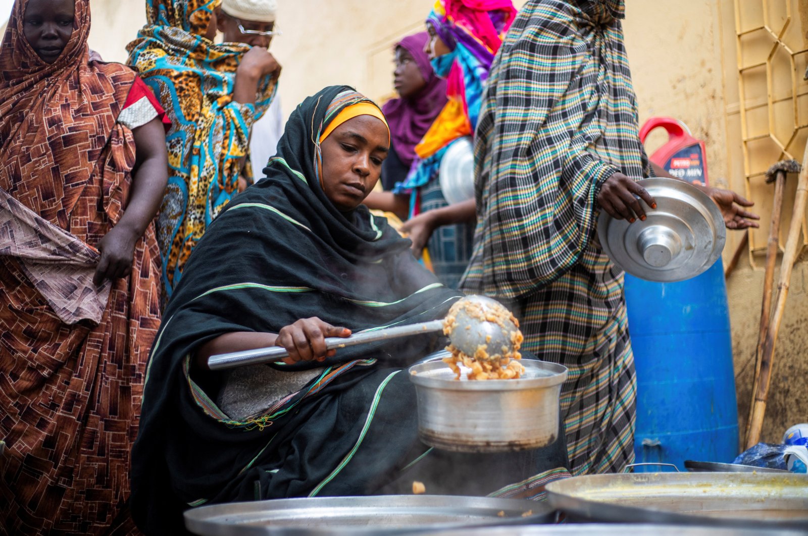 A Sudanese woman from a community kitchen distributes meals for people affected by conflict and extreme hunger, in Omdurman, Sudan, Aug. 22, 2024. (Reuters Photo)