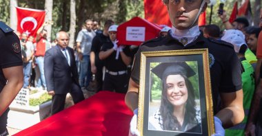 A police officer holds a portrait of Ayşenur Ezgi Eygi during her funeral procession at a cemetery in Didim, Aydın, Türkiye, Sept. 14, 2024. (AA Photo)