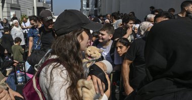 A girl holds a cat as thousands of Turkish citizens wait to evacuate on two Turkish naval vessels at the Port of Beirut, Lebanon, Oct. 9, 2024. (AA Photo)