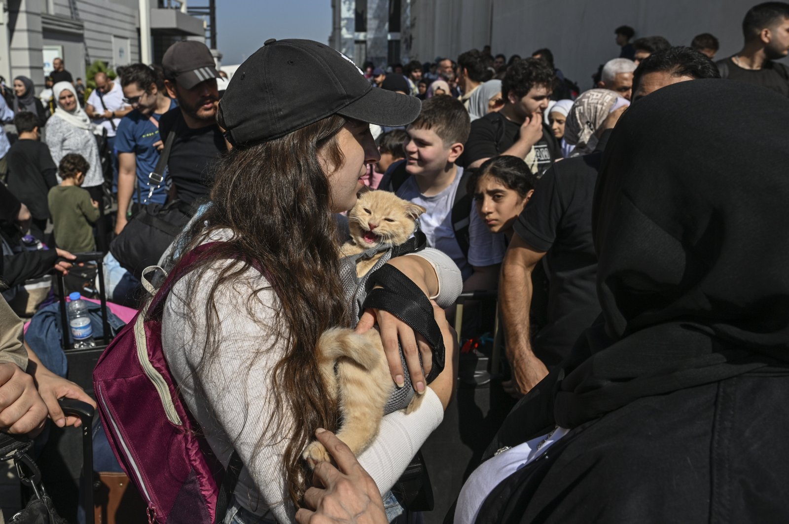 A girl holds a cat as thousands of Turkish citizens wait to evacuate on two Turkish naval vessels at the Port of Beirut, Lebanon, Oct. 9, 2024. (AA Photo)