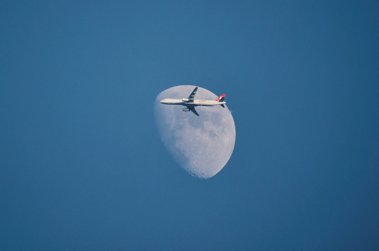 A Turkish Airlines Airbus A321-231 aircraft flies past the moon as it descends for Istanbul Airport, Istanbul, Türkiye, Jan. 1, 2023. (Reuters Photo)