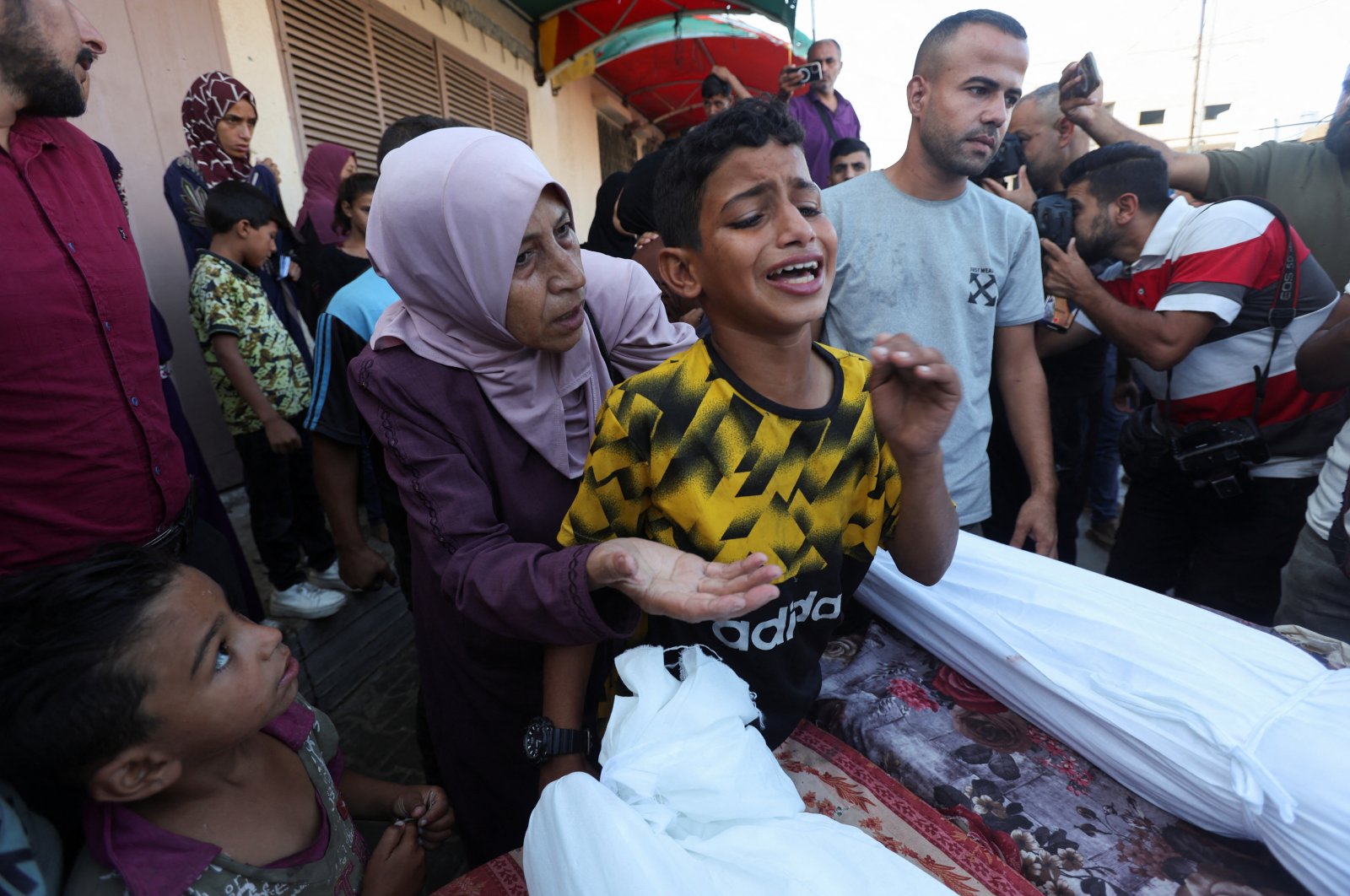 A boy mourns near the body of his father and other Palestinians, who were killed in an Israeli strike at the Al-Aqsa Martyrs Hospital in Deir Al-Balah, central Gaza Strip, Palestine, Oct. 9, 2024. (Reuters Photo)