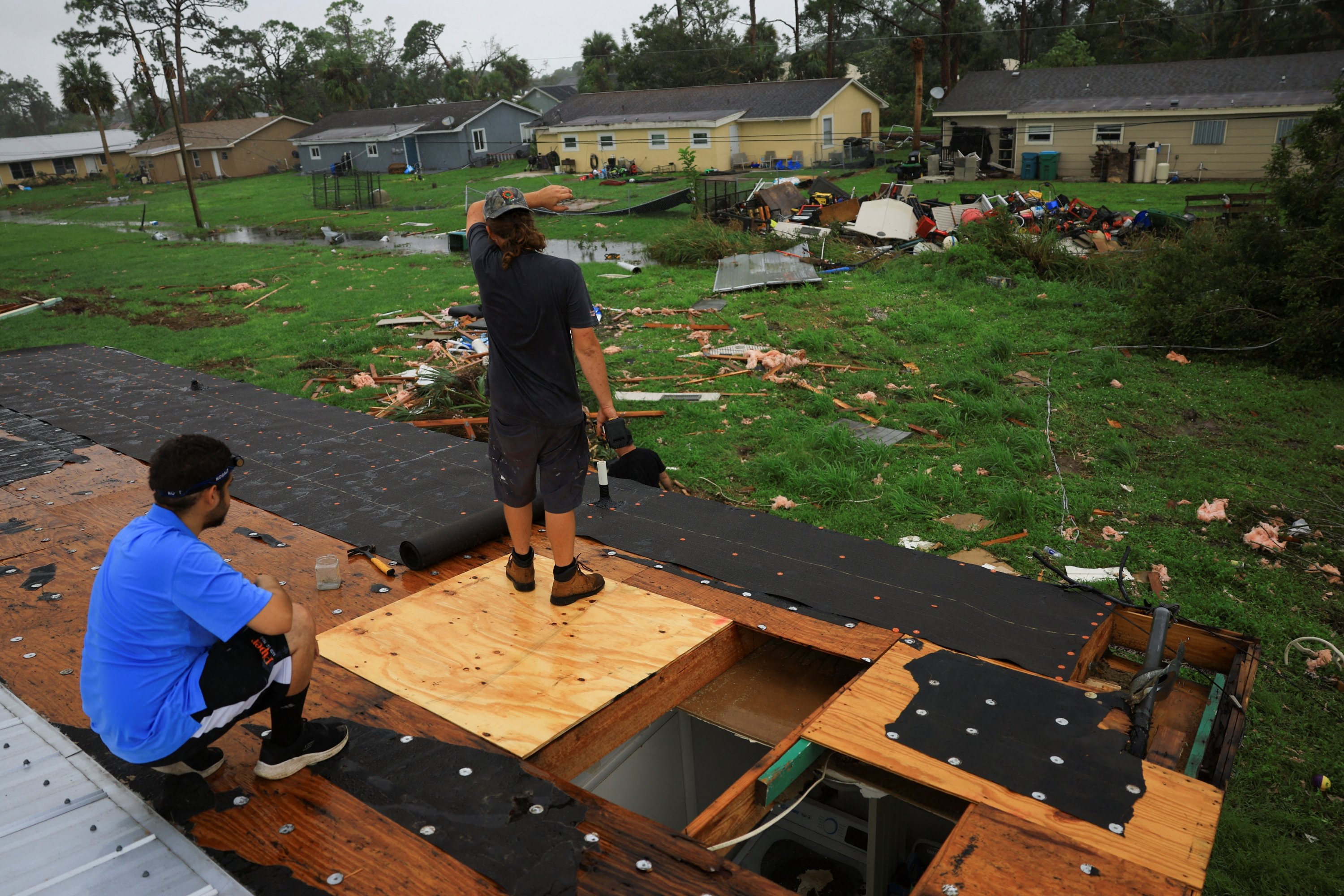 People repair the damaged roof of a property after Hurricane Milton made landfall, in Lakewood Park, near Fort Pierce, in St. Lucie County, Florida, U.S., Oct. 10, 2024. (Reuters Photo)