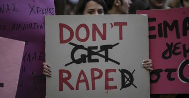 A protester holds a banner during a rally opposing the violence against women and girls, in Athens, Nov. 23, 2019. (AP Photo)