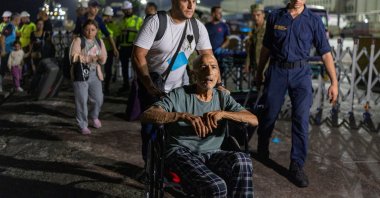 People disembark naval ship TCG Bayraktar carrying people evacuated from Lebanon upon their arrival at a port in Türkiye's Mediterranean coastal province of Mersin, Oct. 10, 2024. (Reuters Photo)