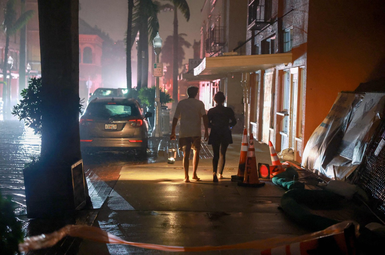 People walk along a street through the wind and rain after power was knocked off as Hurricane Milton made landfall in the Sarasota area in Fort Myers, Florida, U.S., Oct. 09, 2024. (AFP Photo)