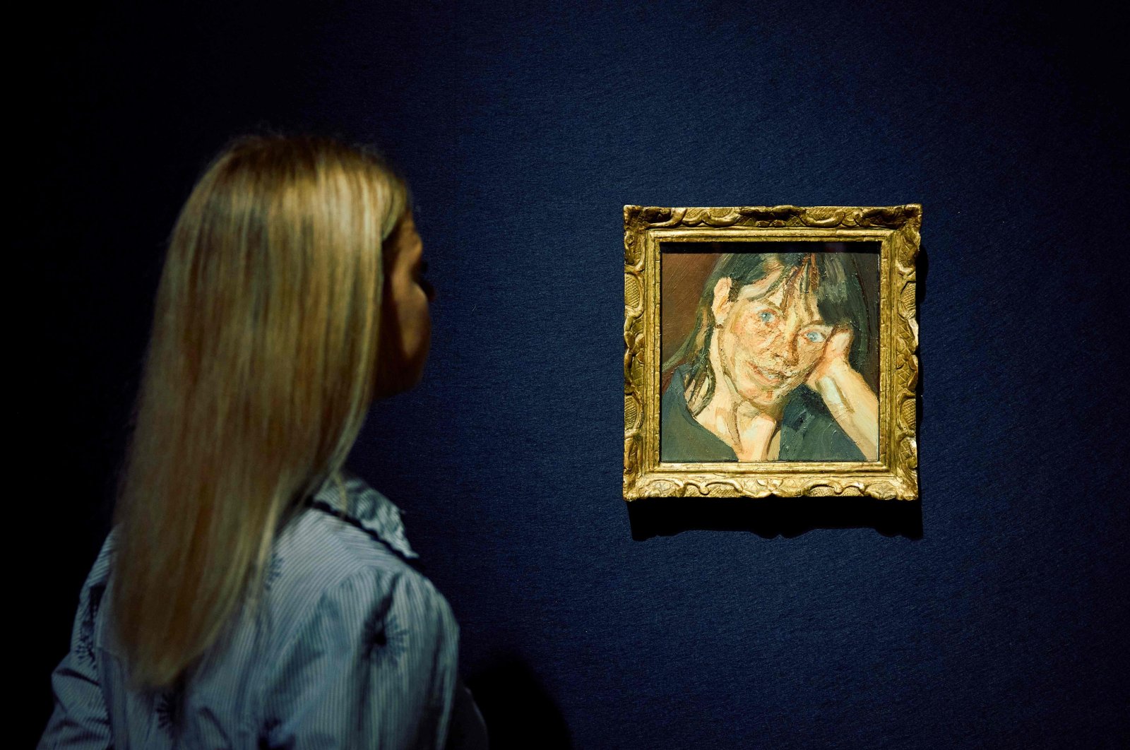 A gallery assistant poses with "Head of a Woman" by Lucian Freud during a photocall for the 20/21 Century London Evening Sale at the Christie's auction house, London, U.K., Oct. 3, 2024. (AFP Photo)