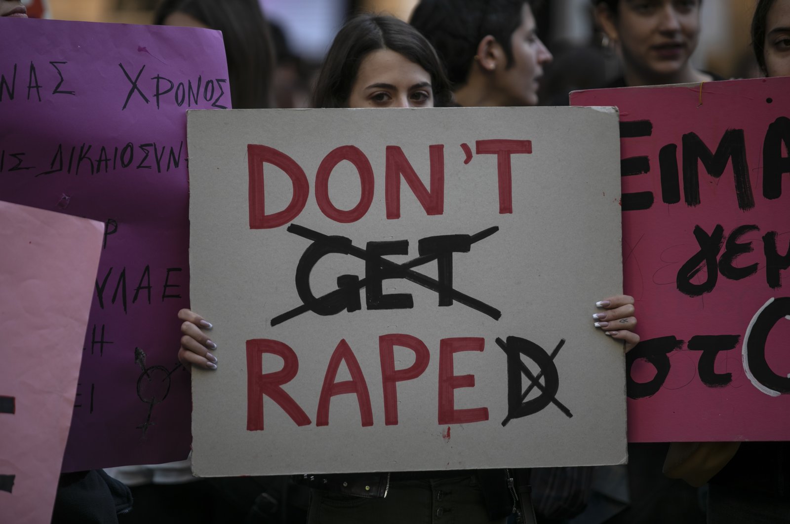 A protester holds a banner during a rally opposing the violence against women and girls, in Athens, Nov. 23, 2019. (AP Photo)