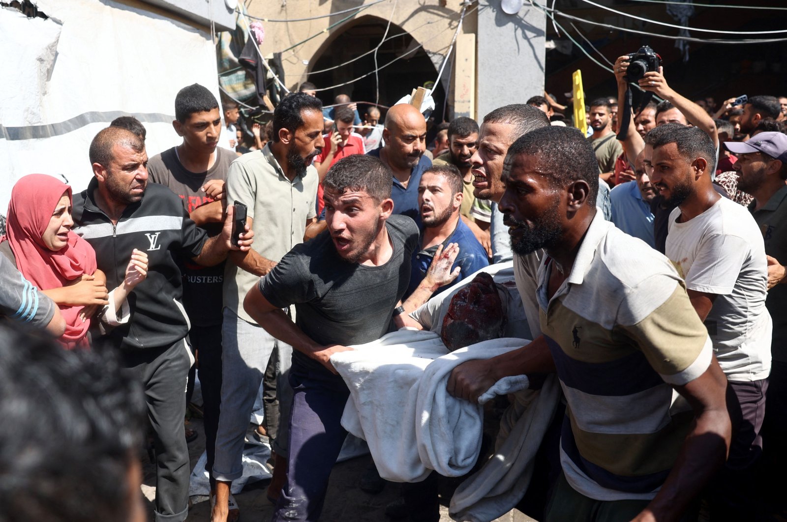 Palestinians carry an injured person after an Israeli strike hit the Rafida school sheltering displaced people in Deir al-Balah, central Gaza Strip, Palestine, Oct. 10, 2024. (AFP Photo)