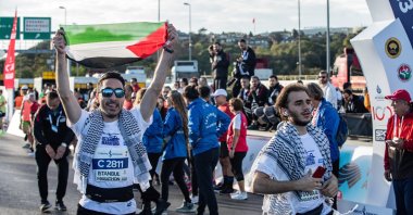 A runner waves a Palestinian flag during the 45th Istanbul Marathon, Istanbul, Türkiye, Nov. 5, 2023. (Getty Images Photo)