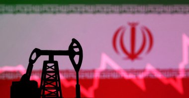 The Iranian flag with a stock graph and an oil pump jack miniature model are seen in this illustration taken Oct. 9, 2023. (Reuters Photo)