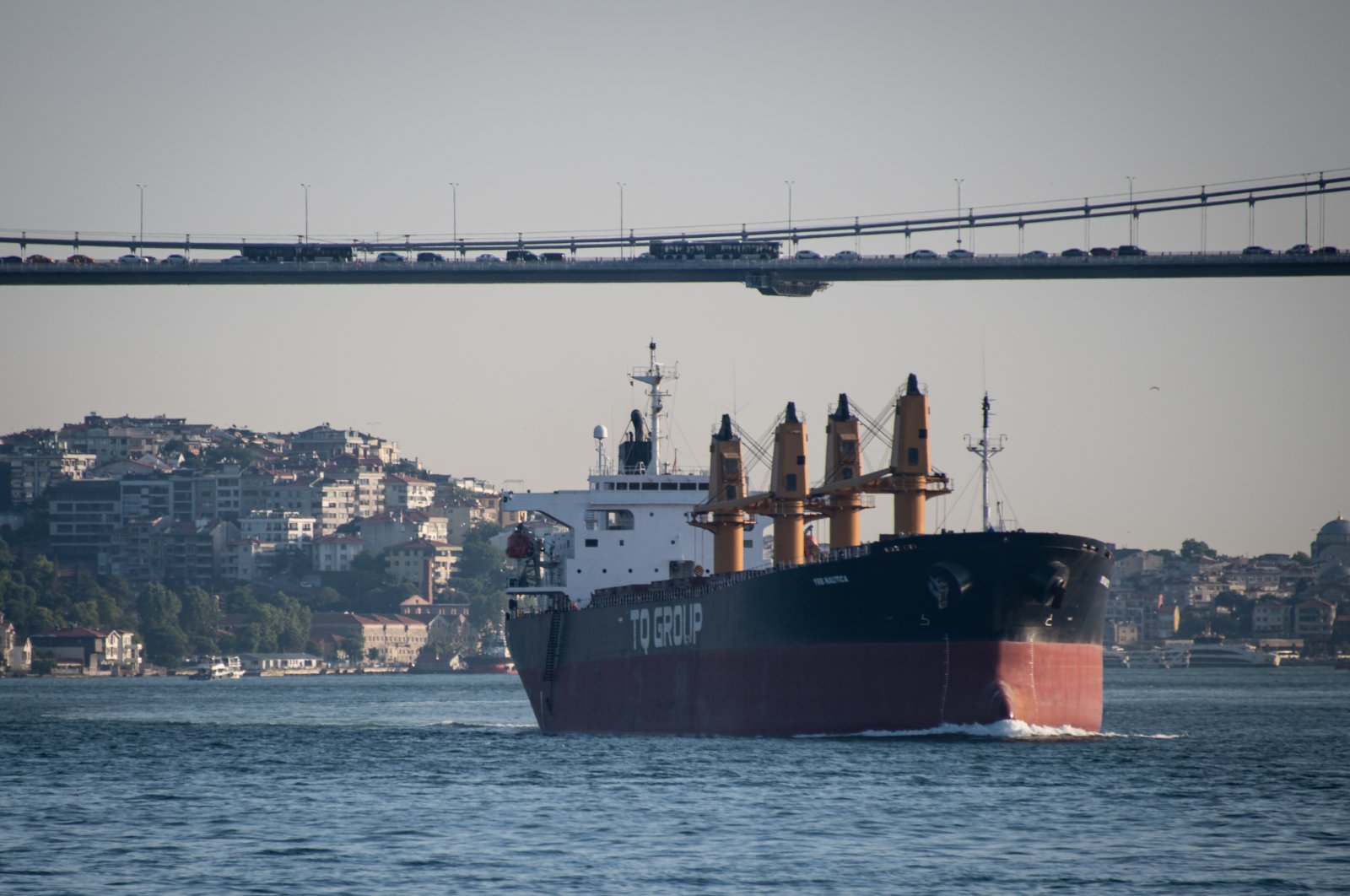 A cargo ship passes under a bridge as it sails through the Bosporus Strait in Istanbul, Türkiye, June 28, 2023. (Reuters Photo)