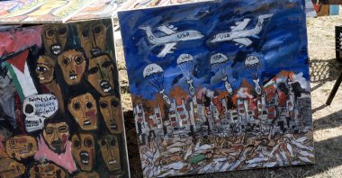 A painting illustrating U.S. fighter jets dropping Israeli bombs over Gaza, Palestine, leaving massacred people and a destroyed city behind, Paterson, New Jersey, U.S. Oct. 6, 2024. (Getty Images)