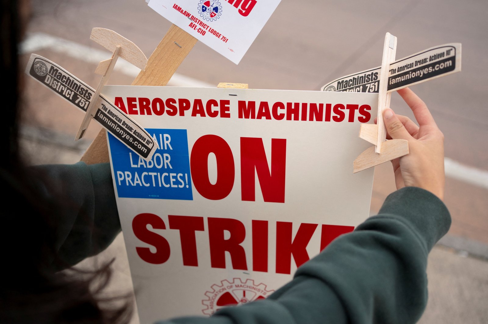 A family member of a Boeing worker decorates a strike sign as Boeing workers and supporters gather on a picket line near the entrance to a Boeing production facility, Renton, Washington, U.S., Oct. 11, 2024. (Reuters Photo)