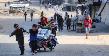 Palestinian children carry their belongings as they flee areas north of Gaza City in the northern Gaza Strip, Palestine, Oct. 12, 2024. (AFP Photo)