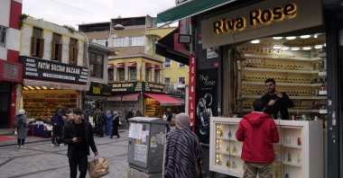 Syrian national Muhammed Abu Samer (R) works in his perfume shop in an open public market in the Fatih district of Istanbul, Türkiye, April 29, 2023. (AP Photo)