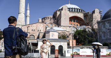 A tourist poses for pictures in front of the Hagia Sophia Grand Mosque on World Tourism Day, Istanbul, Türkiye, Sept. 27, 2024. (EPA Photo)