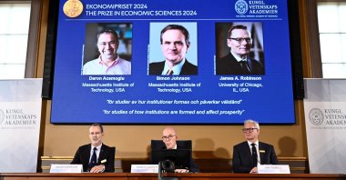 The Nobel Economics Prize is awarded to Daron Acemoğlu, Simon Johnson and James A Robinson, seen on screen during a press meeting at the Royal Swedish Academy of Sciences in Stockholm, Sweden, Oct. 14, 2024. (Reuters Photo)