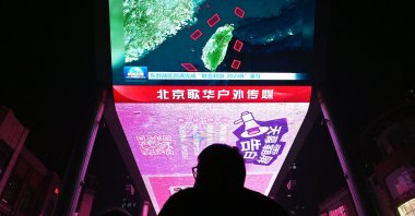 A man watches a news program about Chinese military drills surrounding Taiwan, Beijing, China, Oct. 14, 2024. (AFP Photo)