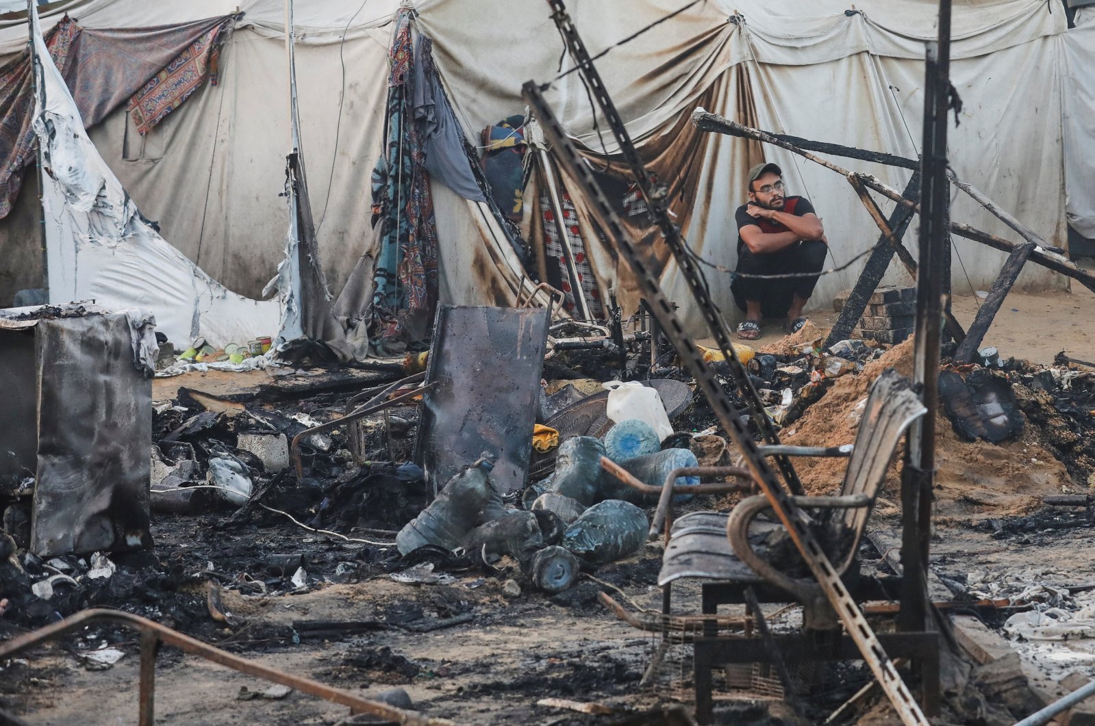 A Palestinian man looks on next to the damage at the site of an Israeli strike on tents sheltering displaced people at Al-Aqsa Martyrs hospital in Deir Al-Balah, in the central Gaza Strip, Palestine, Oct. 14, 2024. (Reuters Photo)