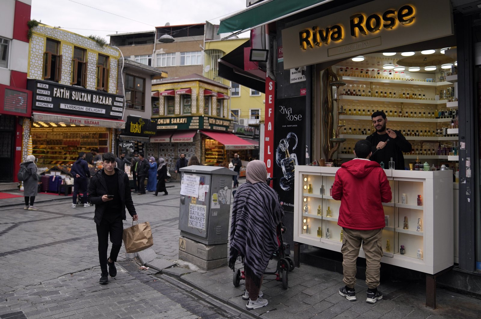 Syrian national Muhammed Abu Samer (R) works in his perfume shop in an open public market in the Fatih district of Istanbul, Türkiye, April 29, 2023. (AP Photo)