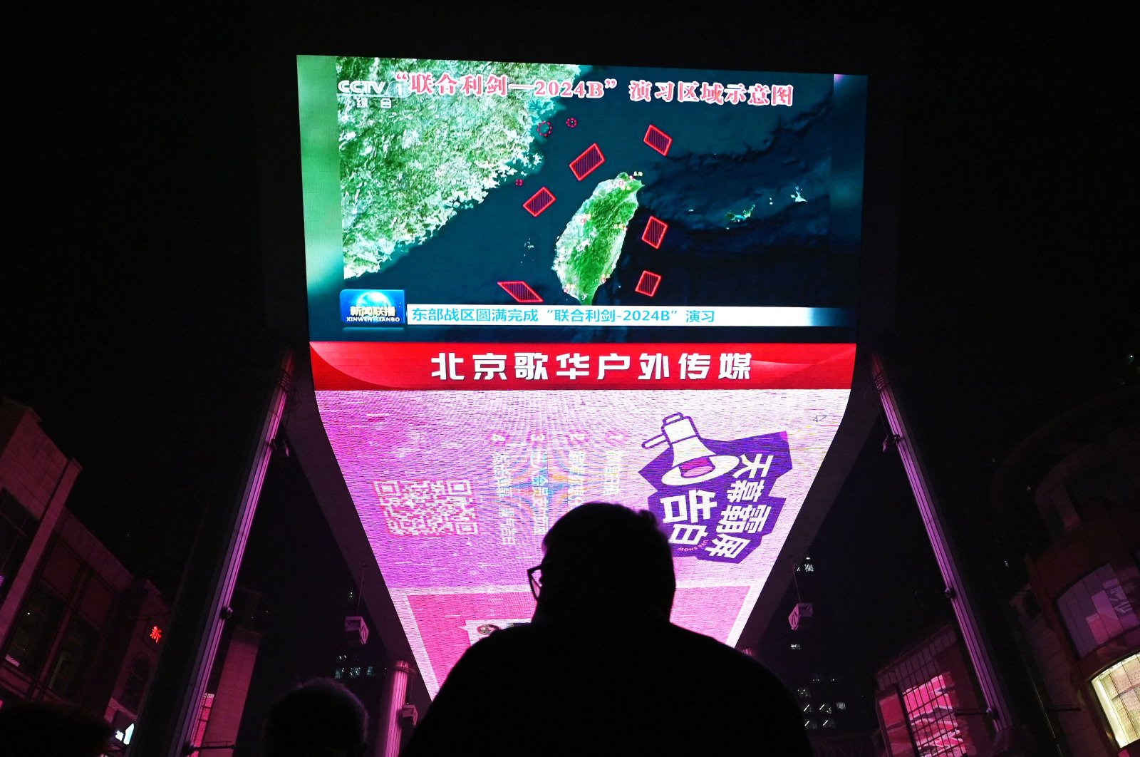 A man watches a news program about Chinese military drills surrounding Taiwan, Beijing, China, Oct. 14, 2024. (AFP Photo)