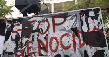People taking part in a pro-Palestinians protest ahead of the Nations League match between Italy and Israel display a banner reading in Italian "Stop Genocide," Udine, Italy, Oct. 14, 2024. (AP Photo)