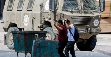 
Palestinians raise their hands as they walk past Israeli forces during an Israeli raid in Qabatiya near Jenin, in the Israeli-occupied West Bank, Sept. 19, 2024. (Reuters File Photo)