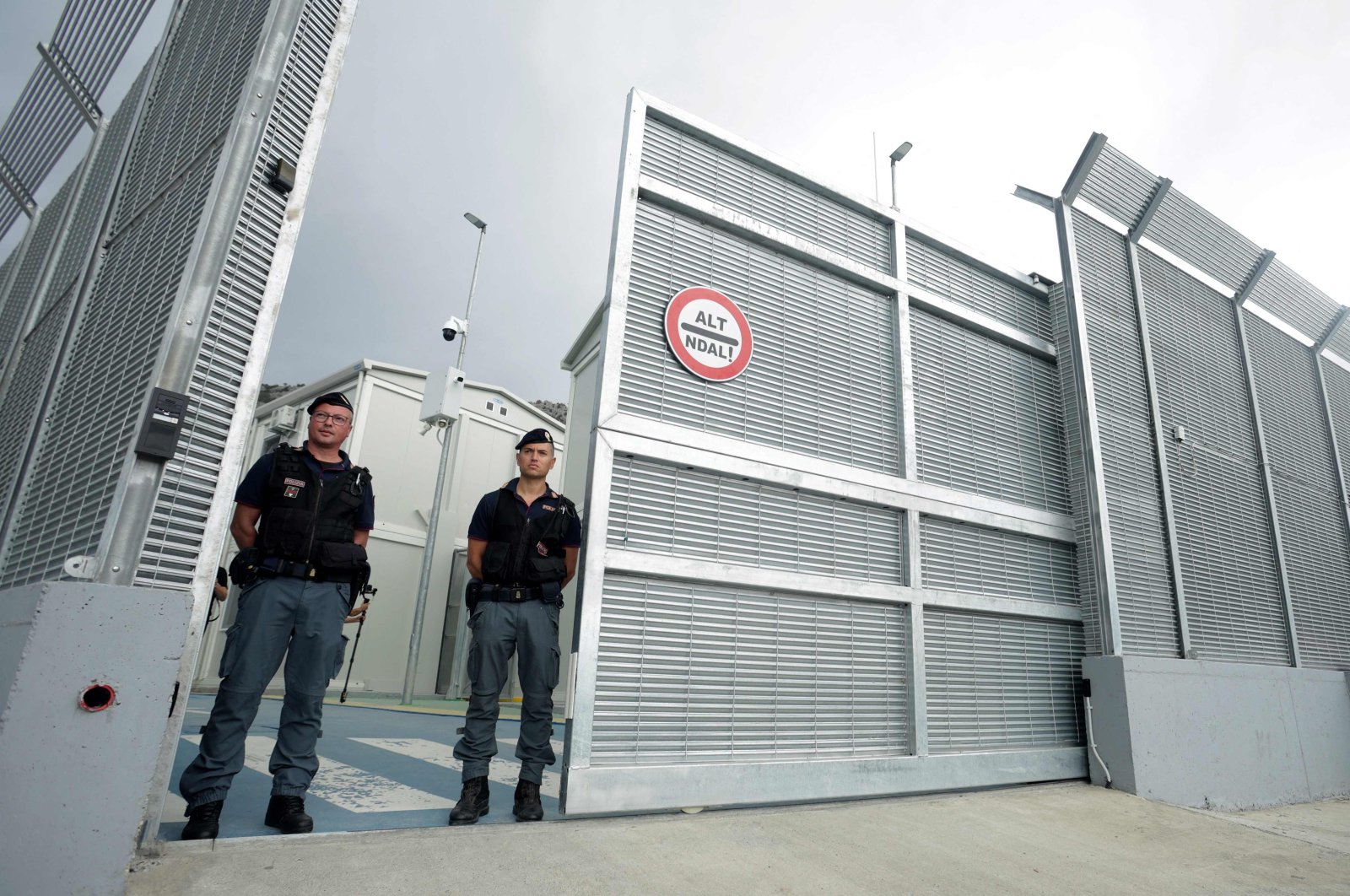 Italian police officers stand at the entrance of a recently built Italian-run migrant center at the port of Shengjin, Albania, Oct. 11, 2024. (AFP Photo)