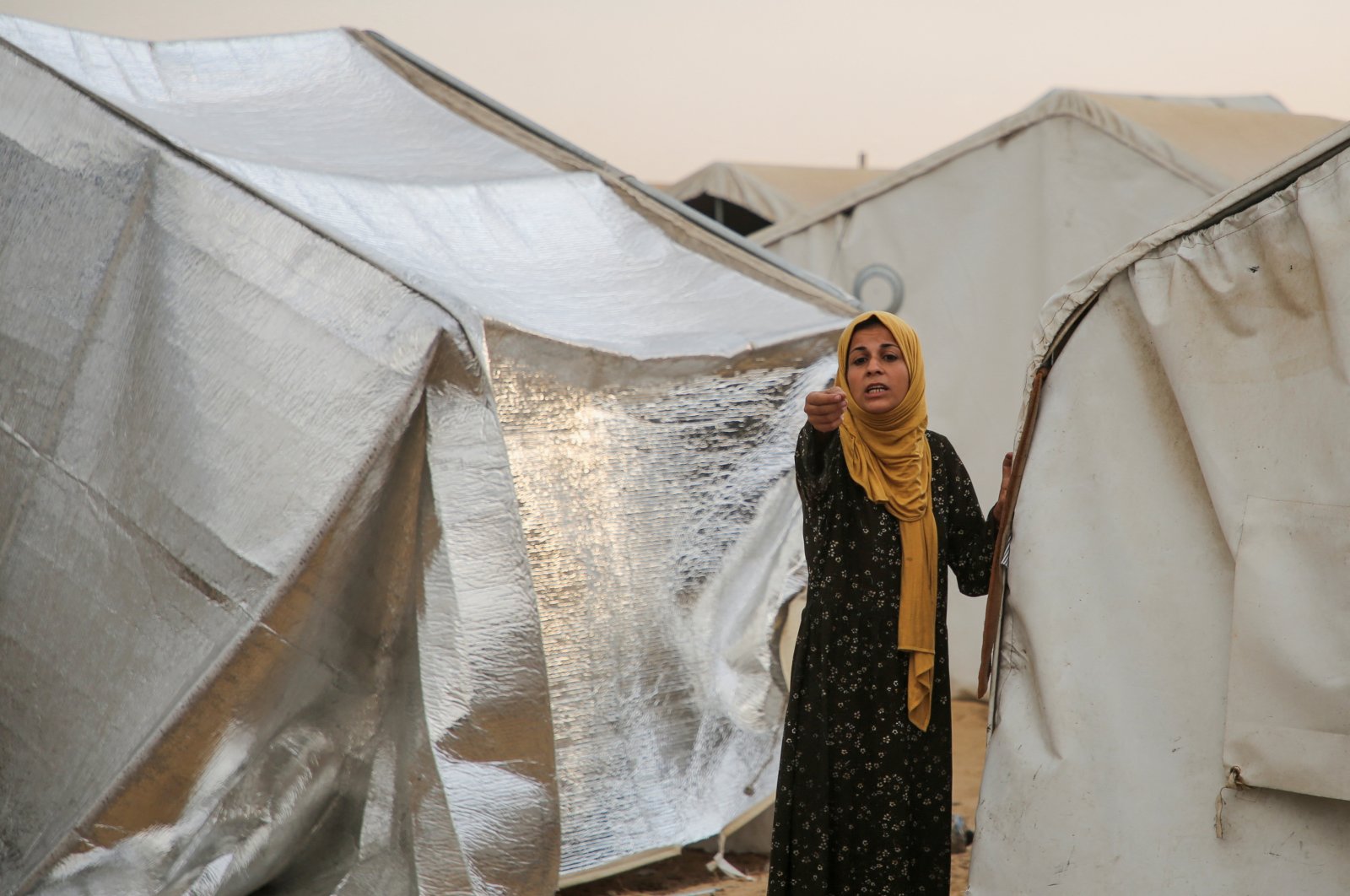 A woman gestures as she reacts while Palestinians inspect the damage at the site of an Israeli strike on a tent camp sheltering displaced people, in the al-Mawasi area of Khan Younis, southern Gaza Strip, Palestine, Oct. 15, 2024. (Reuters Photo)