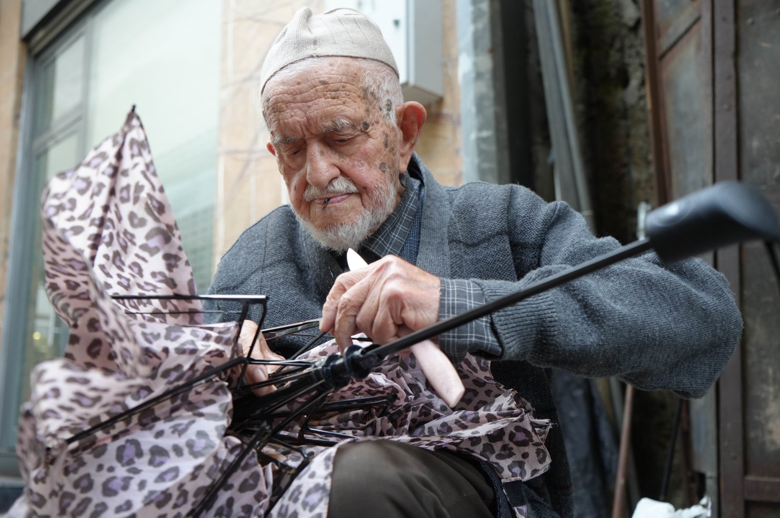 Dursun Yıldız, 95, works on repairing an umbrella, Samsun, Türkiye, Oct. 15, 2024. (IHA Photo)