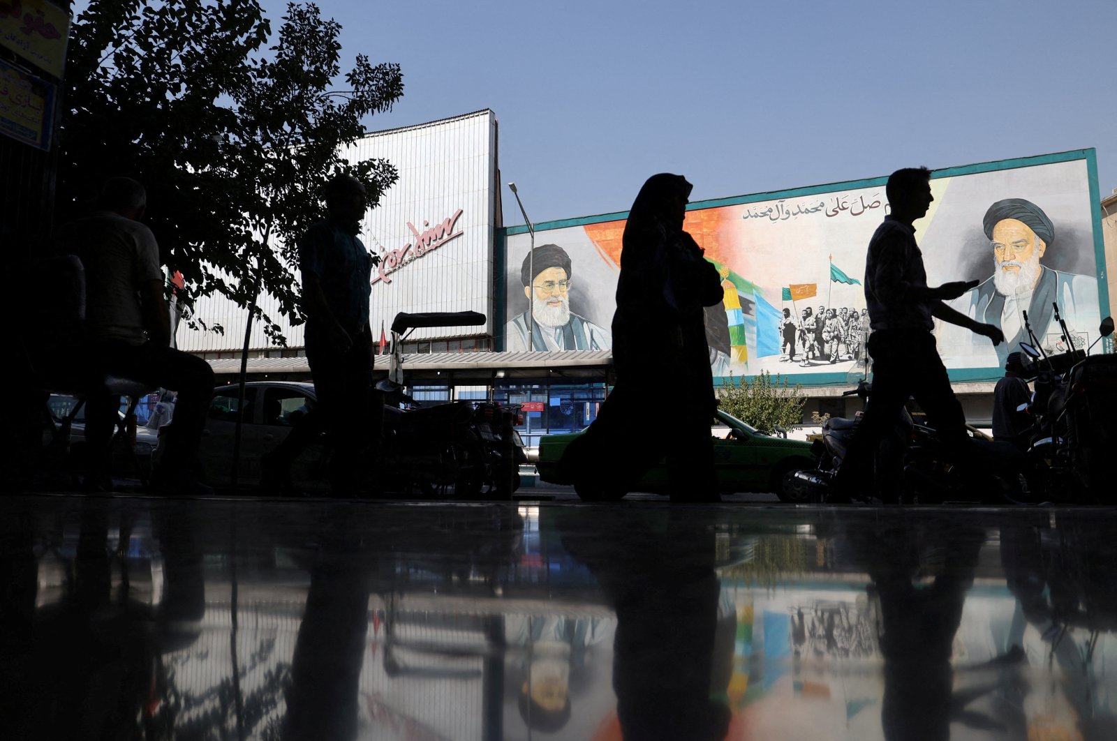 People walk past a mural depicting the late leader of the Islamic Revolution Ayatollah Ruhollah Khomeini and Iran&#039;s Supreme Leader Ayatollah Ali Khamenei on a building in a street in Tehran, Iran, Oct. 7, 2024. (West Asia News Agency via Reuters)