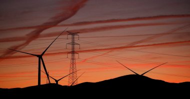 High-voltage power lines, an electricity pylon and wind turbines are seen near Pedrola, Spain, Dec. 12, 2021. (Reuters Photo)
