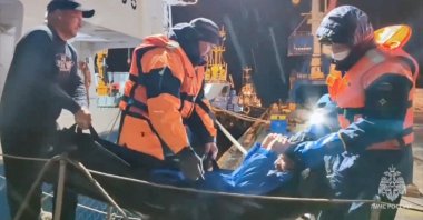 Rescuers leave a vessel while carrying a man, who was reportedly saved after his sailboat had drifted for 67 days in the Sea of ​​Okhotsk, Magadan, Russia, Oct. 15, 2024. (Reuters Photo)