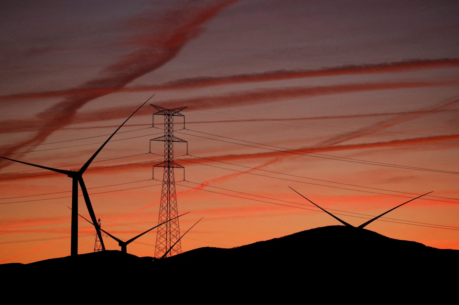 High-voltage power lines, an electricity pylon and wind turbines are seen near Pedrola, Spain, Dec. 12, 2021. (Reuters Photo)