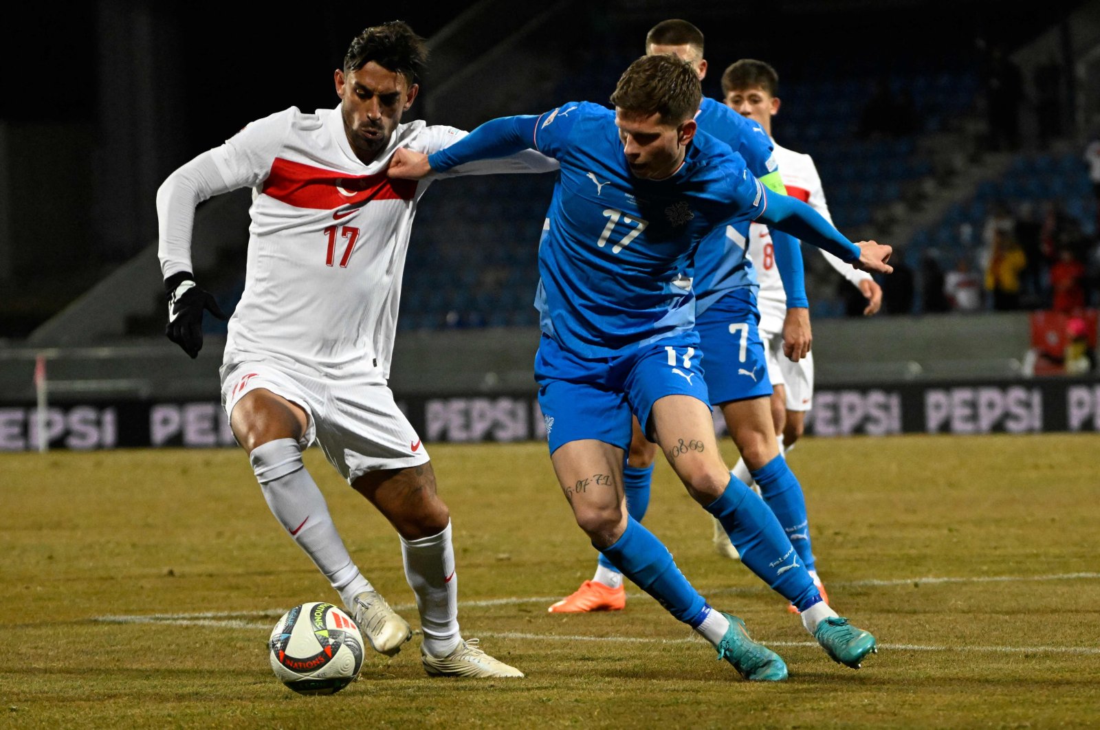 Türkiye&#039;s Irfan Kahveci (L) in action with Iceland&#039;s Logi Tomasson during the UEFA Nations League, League B Group B4 football match at the Laugardsvollur stadium, Reykjavik, Iceland, Oct. 14, 2024. (AFP Photo)