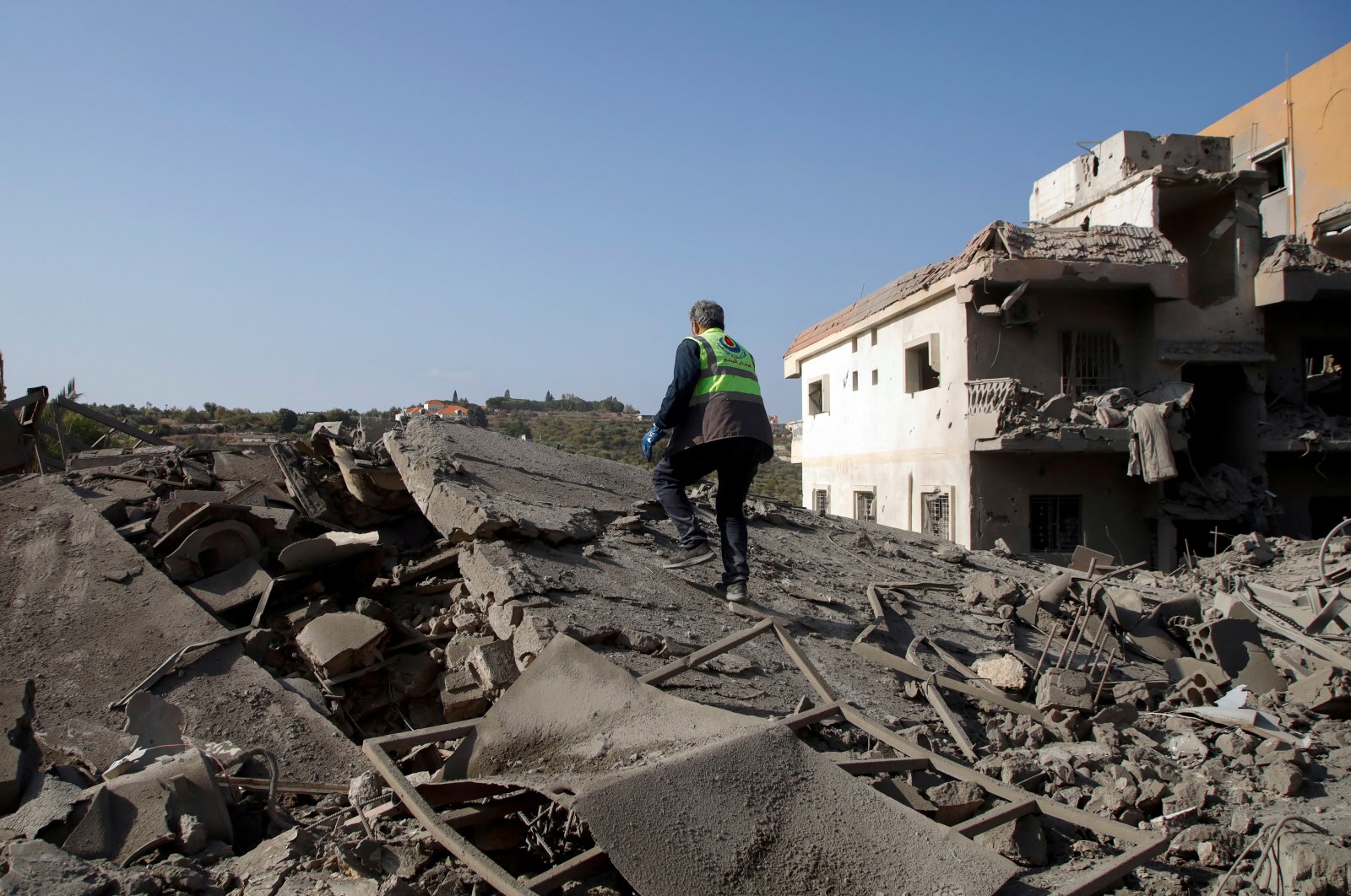 A civil defense member of the Islamic Health Authority walks on rubble at a site damaged by an Israeli strike, in Qana, southern Lebanon, Oct. 16, 2024. (Reuters Photo)