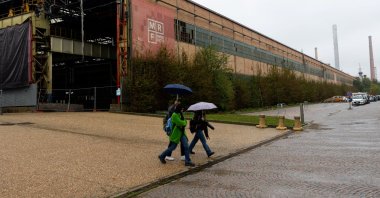 People pass next to a closed part of a Franco-Italian automaker Stellantis factory, Turin, Italy, Oct. 16, 2024. (Reuters Photo)