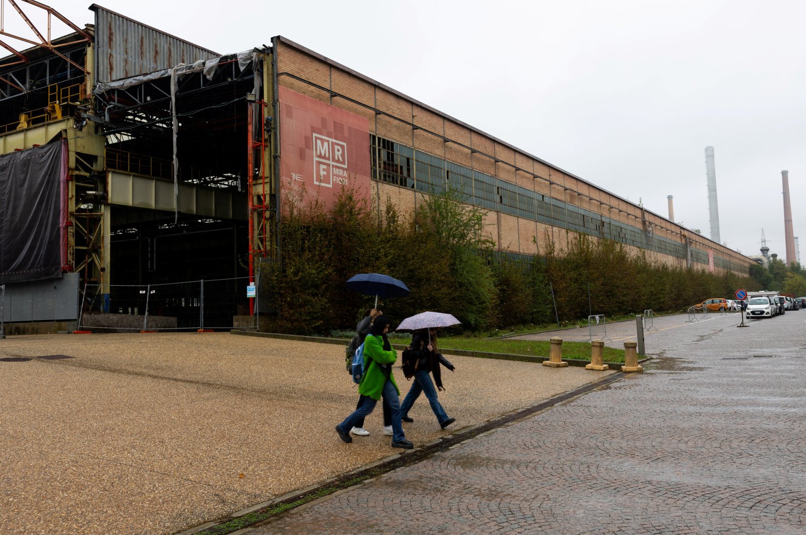 People pass next to a closed part of a Franco-Italian automaker Stellantis factory, Turin, Italy, Oct. 16, 2024. (Reuters Photo)