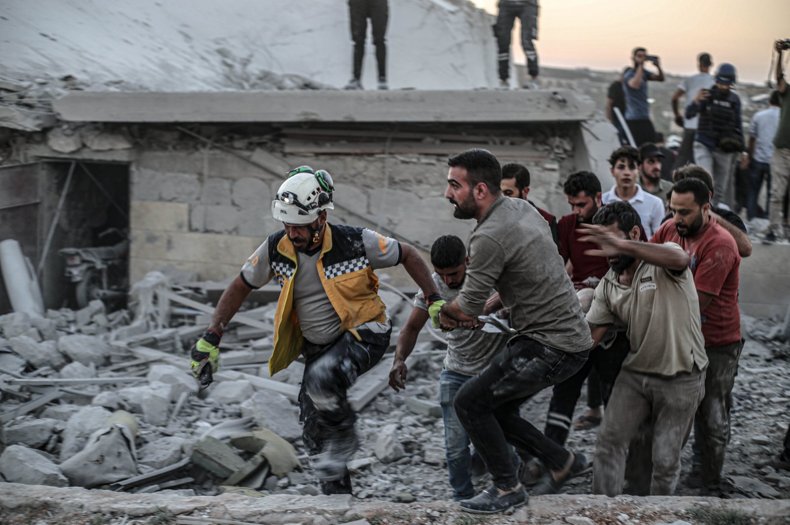 Rescue workers and locals recover a body from the rubble of a building destroyed by a Russian airstrike in Idlib, northern Syria, Oct. 16, 2024. (AA Photo)