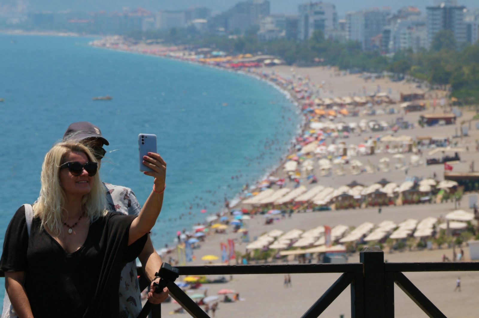 Tourists take a selfie with the backdrop of a beach, Antalya, southern Türkiye, Oct. 1, 2024. (IHA Photo)