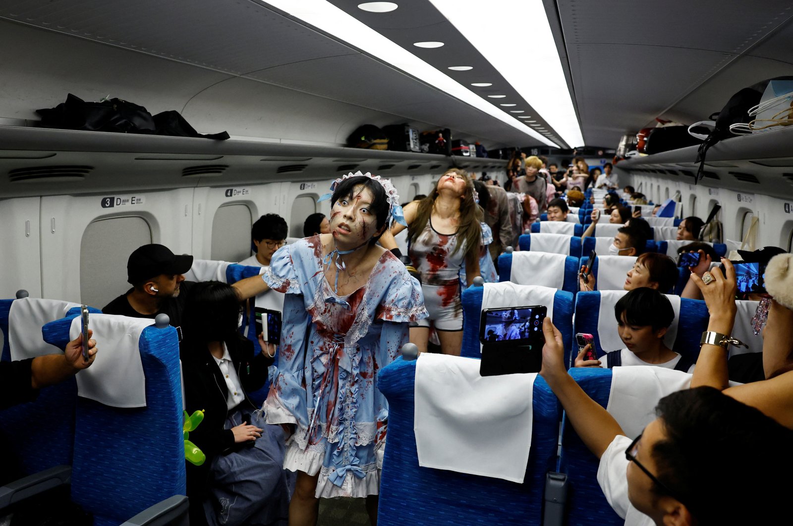 People dressed as zombies perform inside a &quot;Zombie Shinkansen&quot; bullet train bound for Osaka from Tokyo, inspired by the South Korean movie &quot;Train to Busan,&quot; ahead of the Halloween season, Tokyo, Japan, Oct. 19, 2024. (Reuters Photo)