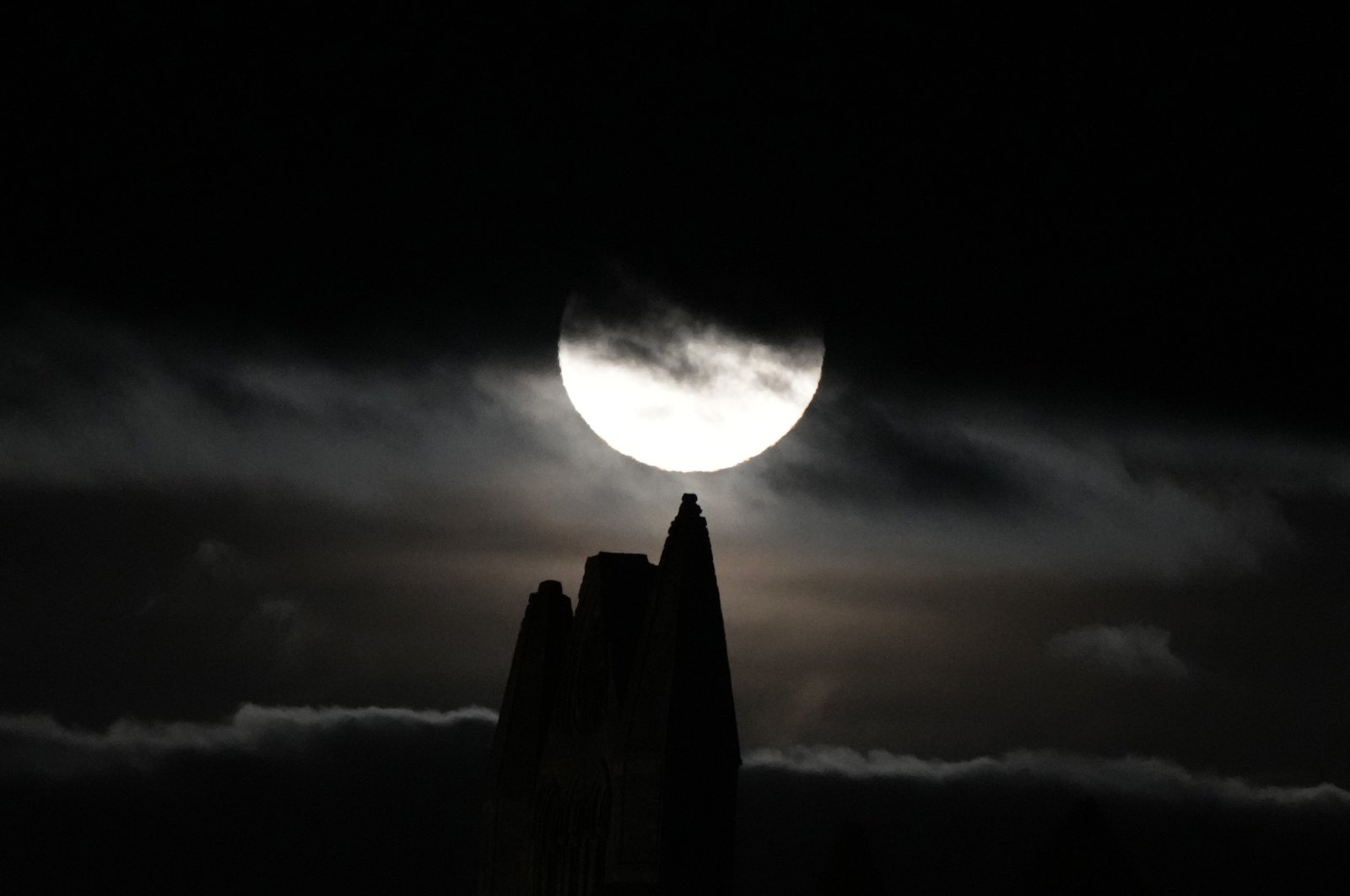 The full moon known as the harvest moon rises over Whitby Abbey, in the town where Irish author Bram Stoker wrote his first notes for his novel Dracula on holiday in 1890, Whitby, U.K., Sept. 20, 2021. (AP Photo)