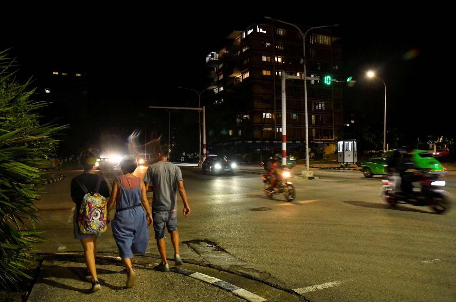 People walk along a street as Cuba&#039;s government said on Saturday it had made some progress in gradually re-establishing electrical service across the island, Havana, Cuba, Oct. 19, 2024. (Reuters Photo)