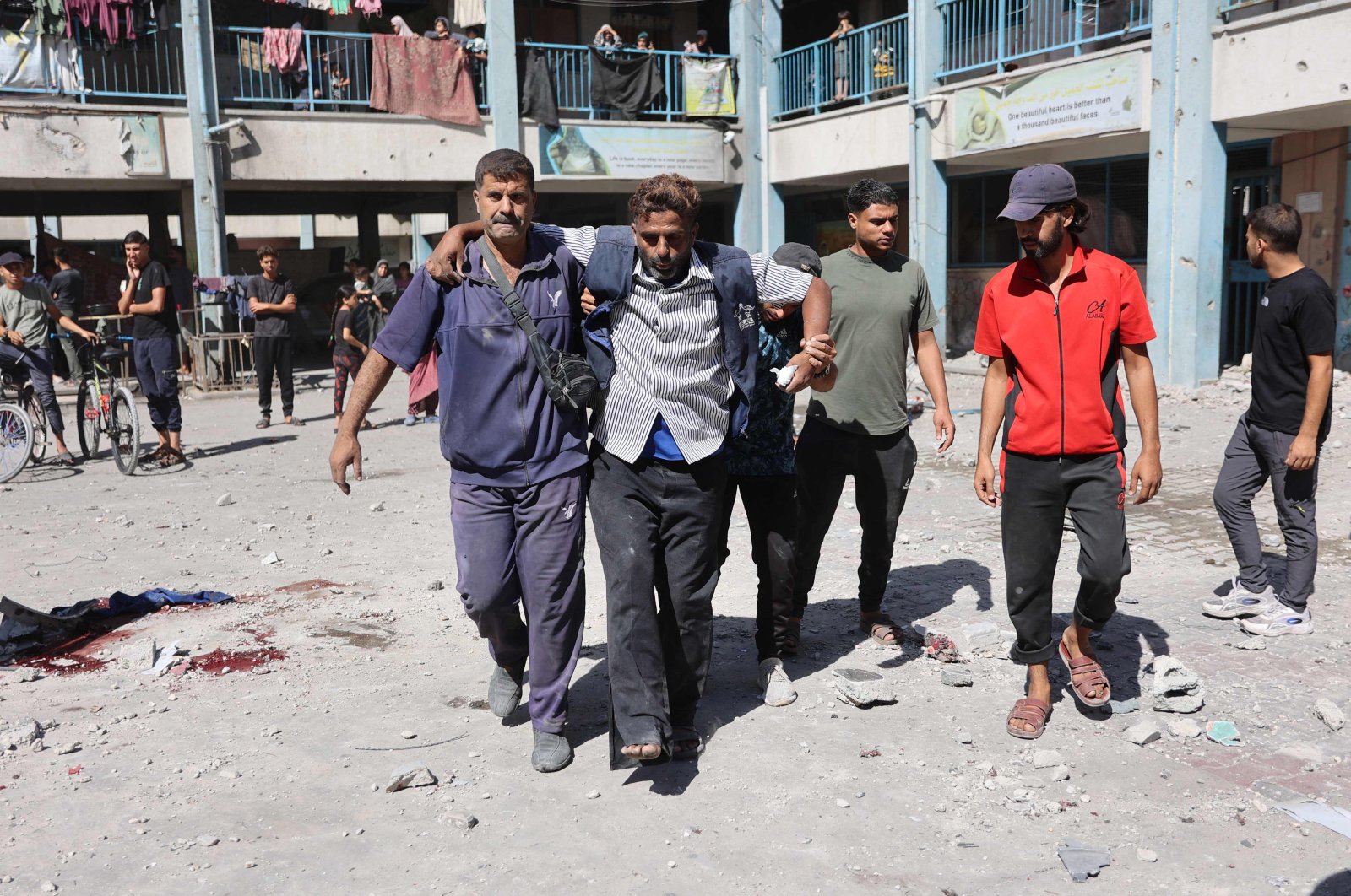 Displaced Palestinians help an injured man in the courtyard of a U.N. school-turned-refuge in the al-Shati refugee camp near Gaza City, northern Gaza Strip, Palestine, Oct. 19, 2024. (AFP Photo)